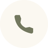Green telephone handset icon inside a light beige circular background.